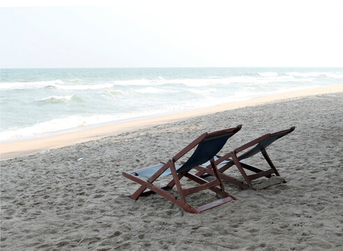Beach chairs are placed on the sand by the sea.
