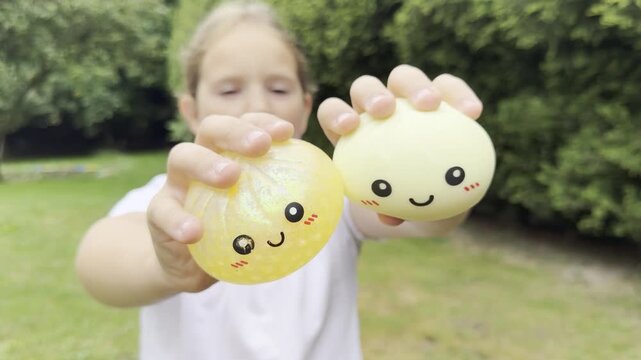 Child holding cute smiling fruits outdoors squishy Rainbow Mystery Bun 
