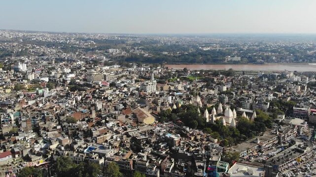 Aerial establishing shot of Old Jammu City, Tawi River, Raghunath Temple and dense urban sprawl in Jammu.