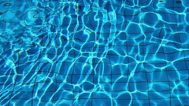 Texture details of the blue water of a swimming pool on a sunny day