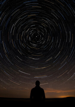 Silhouette Of A Person Stargazing Under A Starry Night Sky With Vibrant Stars And Cosmic Patterns In The Background
