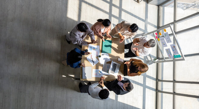Top view of entrepreneurs team and startup have business meeting and encouraging other by clapping hands for good spirit applause to accomplish successful marketing plan