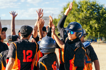 Obraz premium Youth baseball players celebrating victory and teamwork on the field. Young athletes showing spirit and unity during a game
