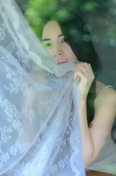 Ethereal Portrait of Young Woman Holding Delicate Lace Fabric