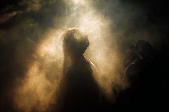 Shamanic smoke ritual silhouette with dramatic backlight and swirling mist for spiritual event poster or atmospheric background design