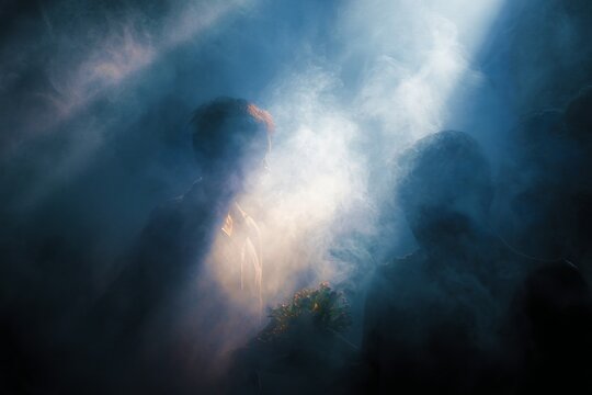 Shaman smoke ritual with dramatic light and silhouettes for sacred ceremony background and spiritual poster design