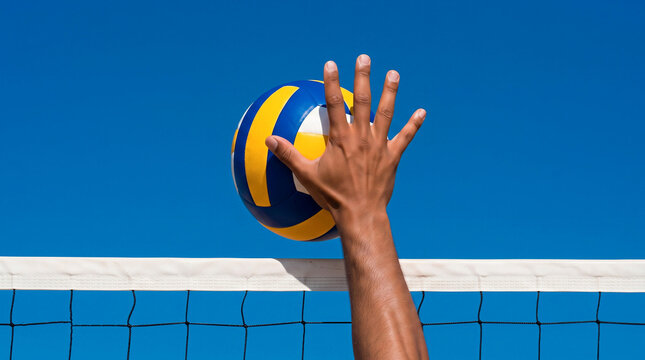 Close-up of a volleyball player's hand reaching to spike or block a ball over the net against a clear blue sky