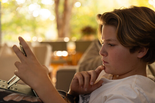 profile of young boy looking at tablet computer at home