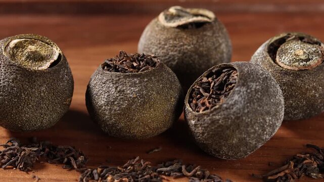 Close up of traditional Chinese Xiao Qing Gan mandarin pu-erh tea on wooden table