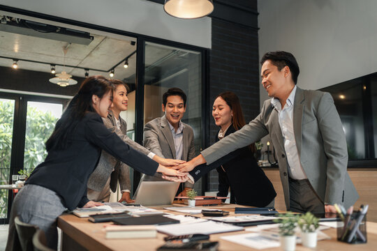 Business professionals collaborate success stacking hands modern office meeting room achieving corporate goals together partnership strategy development unified team support vision