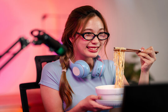 Woman streamer eats ramen noodles with chopsticks for a snack br