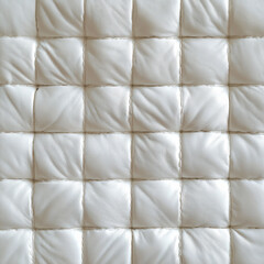 Fototapeta premium Close-up view of a white quilted fabric texture with a repeating square pattern.