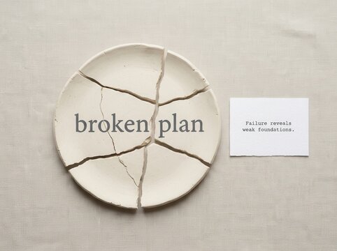 A cracked ceramic plate with the words "broken plan" and a quote about failure