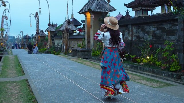 Tourists happily walk at Penglipuran Village, the oldest Balinese village in Bali, Indonesia.