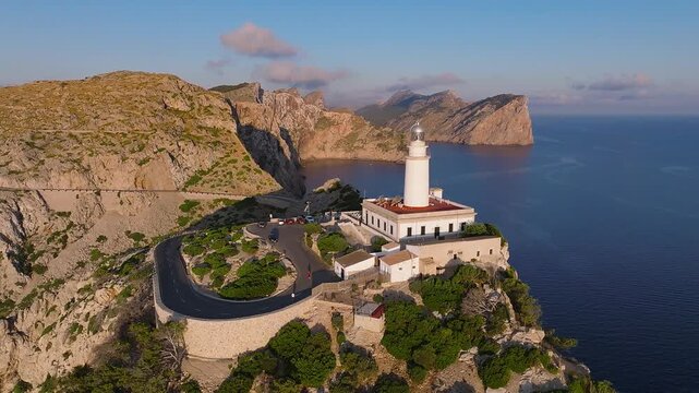 Mallorca, Spain - 4K Flying by the Lighthouse at Cap de Formentor at sunrise with amazing golden coloured cliffs and colorful clouds at background
