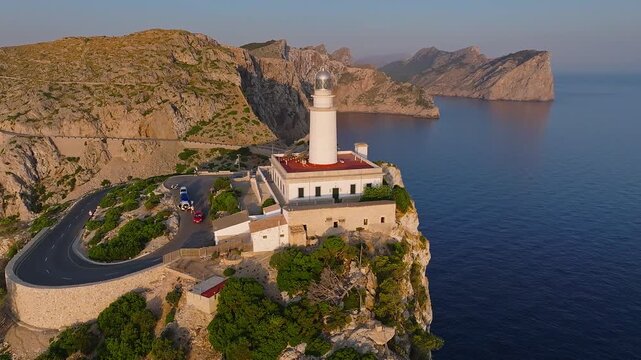 Mallorca, Spain - 4K Flying around of the Lighthouse at Cap de Formentor at sunrise with amazing golden coloured cliffs and colorful clouds at background