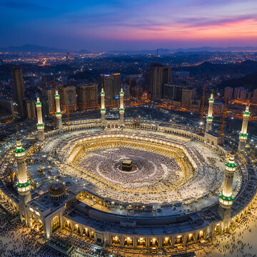 Aerial view of illuminated grand holy mosque courtyard at dusk with city lights
