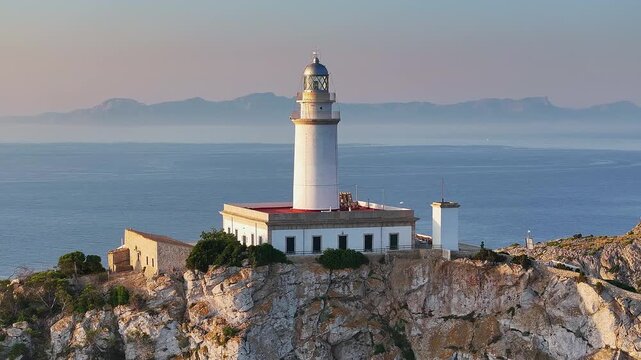 Mallorca, Spain - 4K Flying around of the Lighthouse at Cap de Formentor at sunrise with amazing golden coloured cliffs at background