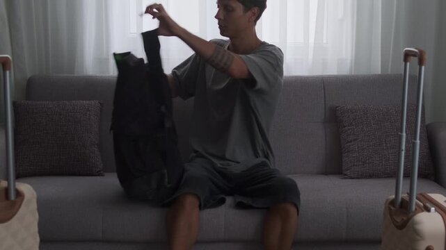 Remote work without borders. Man arriving with luggage and immediately starting work on laptop in temporary accommodation