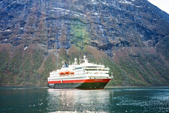 Hurtigruten's MS Nordkapp anchors in the small village Urke in Hjorundfjord, Norway, on a sunny spring day