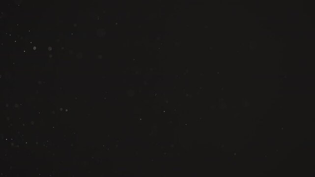 Floating dust particles over dark background with shallow focus