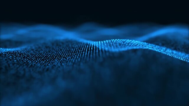 Abstract digital loop of flowing blue particle waves with a shallow depth of field