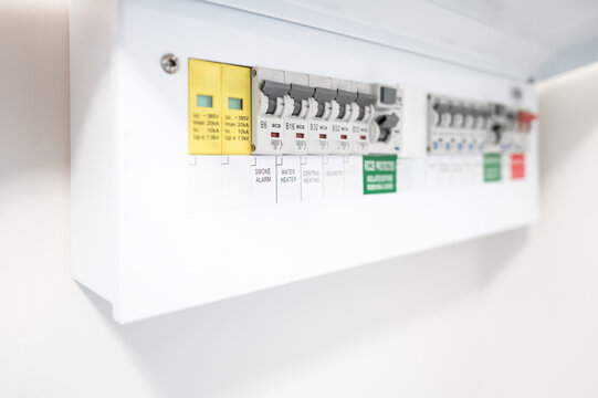 Close-up of a newly installed electrical distribution and safety panel showing individual circuit breakers and the red coloured mains electric cut off switch. Seen in a newly renovated apartment.