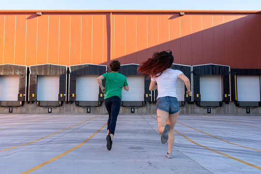 Two acrobats running during training, rear view