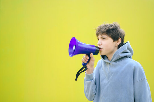 Activist shouting through a purple megaphone against a yellow wall