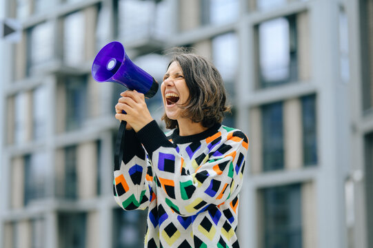 A woman shouts into a loudspeaker during an outdoor city rally