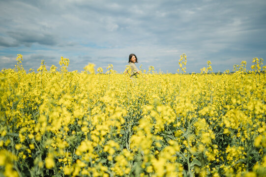 Smiling and enjoying solitude in a yellow rapeseed field
