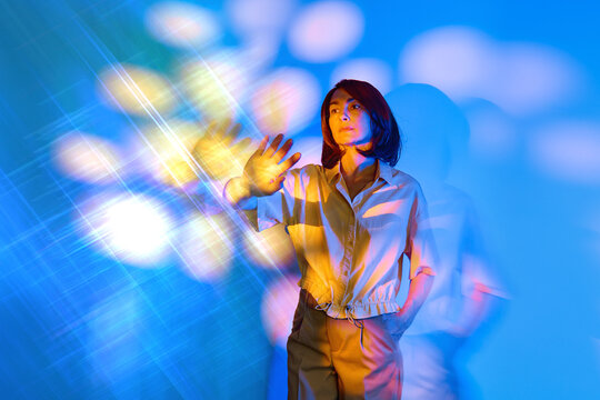 Woman touches a glowing virtual interface in a surreal future