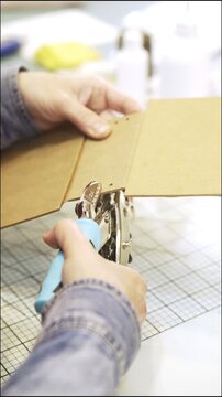 Woman's hands using a hole puncher for scrapbooking