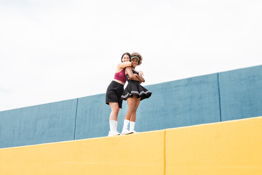 Smiling mid adult women standing on retaining wall