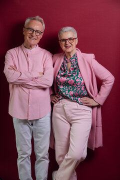 Portrait of confident senior couple against purple background
