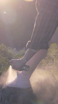 Applying Insect Repellent on Legs Before Hiking Running Walking or Outdoor Recreation at Sunset
