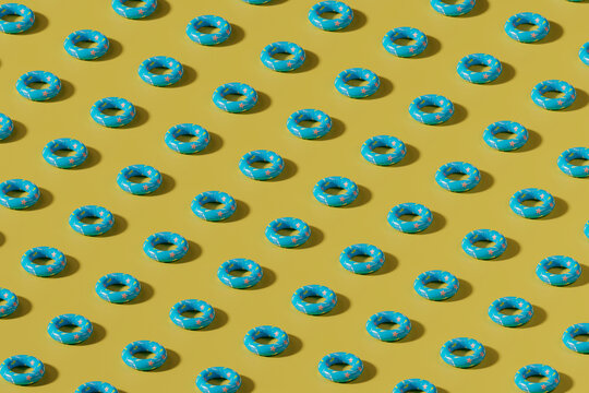 Pattern of blue inflatable swimming rings on yellow background