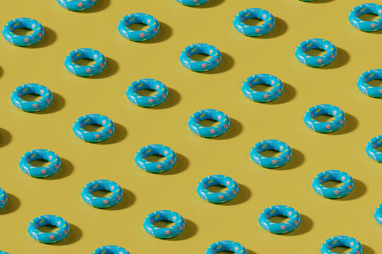 Blue inflatable swimming ring pattern on yellow summer background
