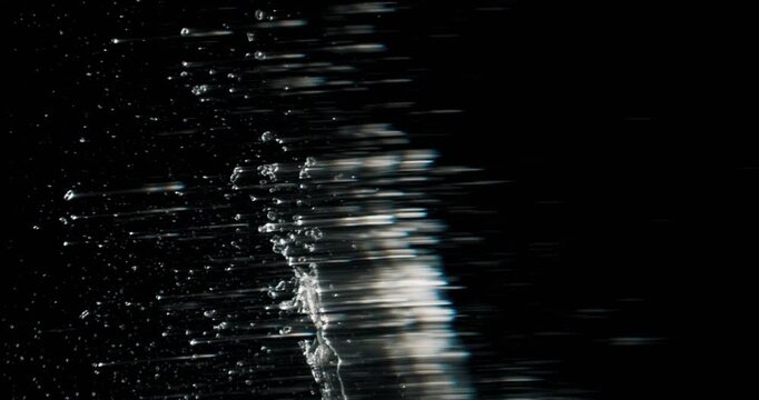 A stunning and dynamic water splash is skillfully captured against a deep black background, making it an ideal choice for various motion graphics and abstract designs that require visual impact