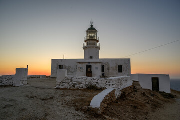 Armenistis Lighthouse compound on Mykonos at dusk with stone walls and orange twilight glow on the horizon, Cyclades, Greece © Michal Plevko