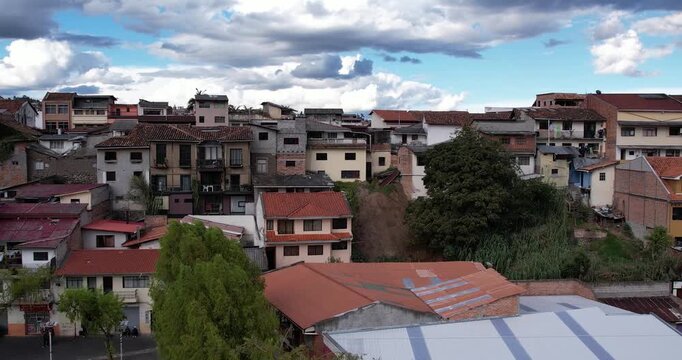 cinematic aerial drone footage capturing the historic center of cuenca ecuador and the famous colonial casas del barranco overlooking the tomebamba river on a beautiful clear sunny day in the city