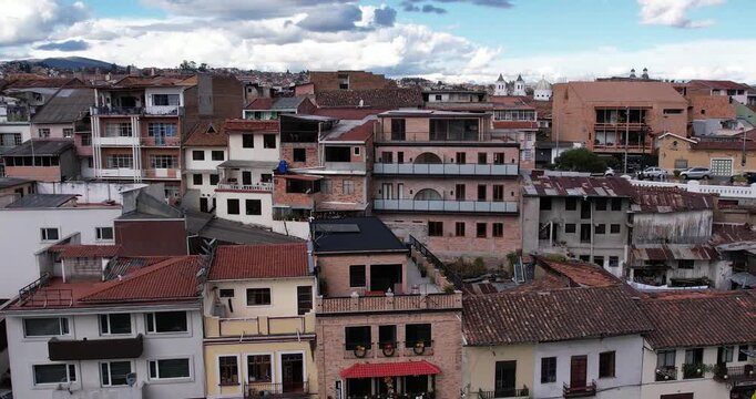 cinematic aerial drone footage capturing the historic center of cuenca ecuador and the famous colonial casas del barranco overlooking the tomebamba river on a beautiful clear sunny day in the city