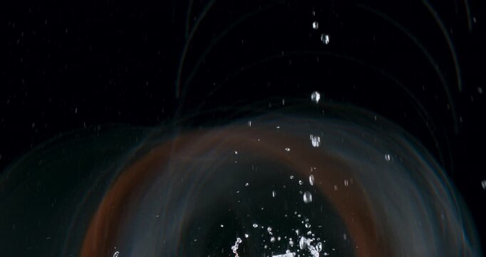 The stunning footage of water droplets splashing on a sleek black background is perfect for creating vibrant motion graphics and visual effects that captivate and mesmerize viewers