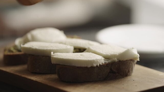 man making bruschetta with pesto and mozzarella