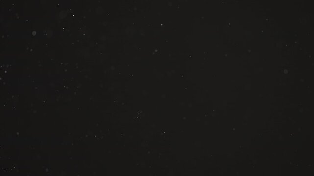 Floating dust particles over dark background with shallow focus
