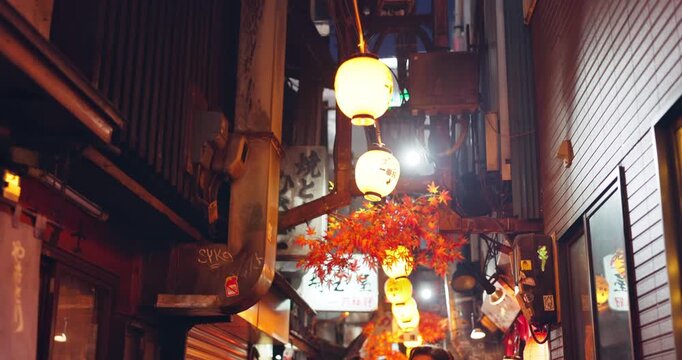 City, Japan and night market with people outdoor at Omoide Yokocho for tourism or travel. Lights, location and walking with tourists in urban town for holiday or vacation to experience culture