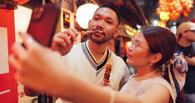 Asian couple, market or selfie with food, skewers or kebabs for traditional or local cuisine in Japan. Japanese, man and woman with picture, photography or memory for omoide yokocho together in Tokyo