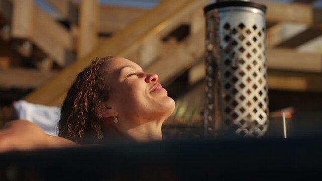 With sunlight on the water, the woman lingers in a quiet hot tub retreat