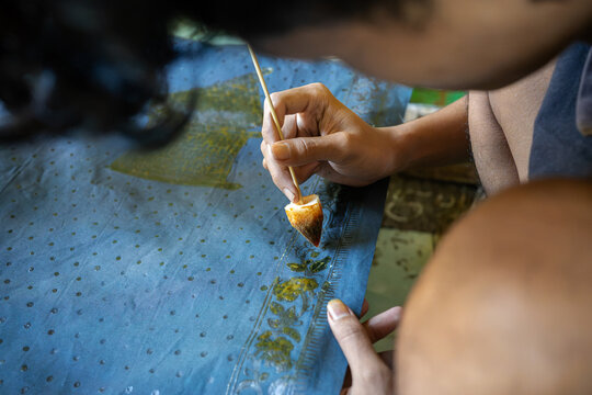 Close Up of Batik Artisan Creating Floral Wax Pattern on Fabric