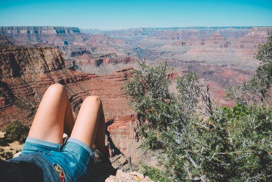 USA, Arizona, Grand Canyon National Park, legs of tourist relaxing at Grand Canyon